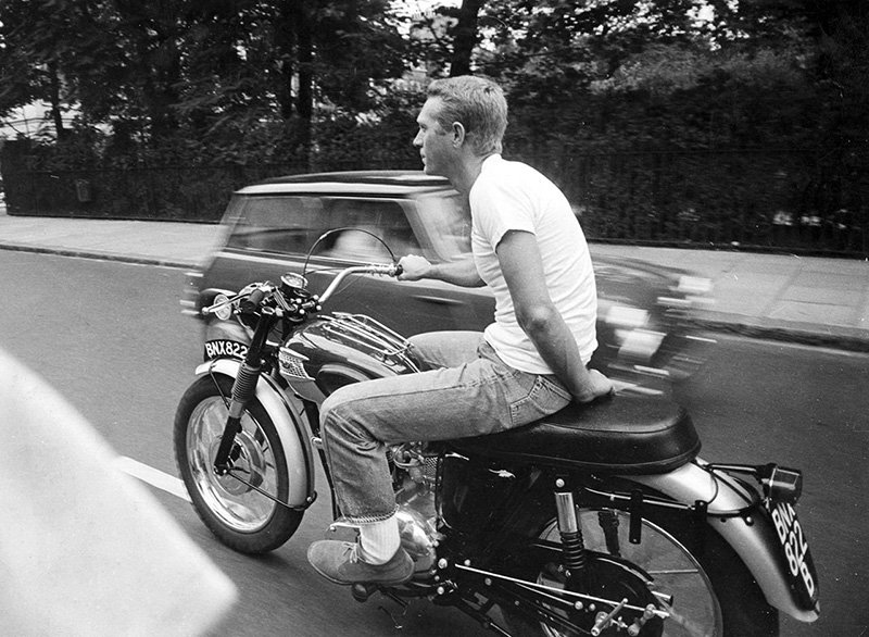 Steve McQueen wearing jeans on motorcycle